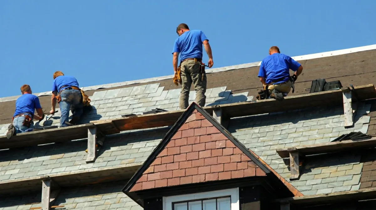 Roof replacement in progress with a team of professional contractors installing new shingles on a residential home in Madison, WI